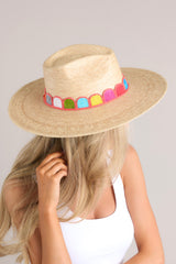 This palm hat features a woven striped band, and is handmade with palm fronds.