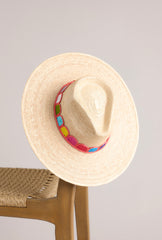 Top view of this hat that features a woven striped band, and is handmade with palm fronds.