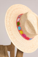 Close up view of this hat that features a woven striped band, and is handmade with palm fronds.