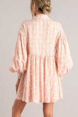 Back view of this dress that features a collared neckline, functional buttons down the front, long sleeves with smocked cuffs, and a flowy, relaxed fit throughout.