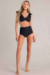 Full body front view of these bikini bottoms that feature a high waisted design, ruching on the sides, and a full coverage backside.