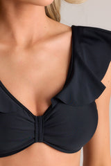 Close up view of this bikini top that features a v-neckline, removable padding, gathering in the center, self-tie feature in the back, and ruffled sleeves.