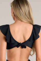 Back view of this bikini top that features a v-neckline, removable padding, gathering in the center, self-tie feature in the back, and ruffled sleeves.