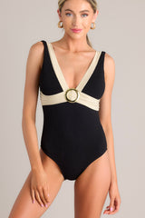 Front view of this one piece that features a v-neckline, a gold accent ring, shimmer detailing, a textured material, an open back, and a full coverage backside.