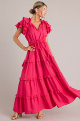 This pink dress features a v-neckline with a self-tie closure, ruffled flutter sleeves, a drawstring waistband, and a long, flowy skirt.