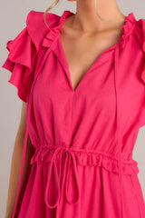 Close up view of this dress that features a v-neckline with a self-tie closure, ruffled flutter sleeves, and a drawstring waistband.