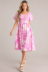 Full body view of this dress that features an elastic square neckline, a fully smocked bodice, functional hip pockets, and flowy short sleeves.