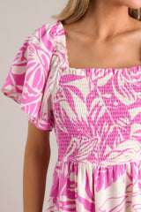 Close up view of this dress that features an elastic square neckline, a fully smocked bodice, functional hip pockets, and flowy short sleeves.