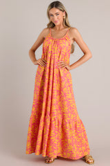 Full body view of this dress that showcases an orange floral print over a pink background.