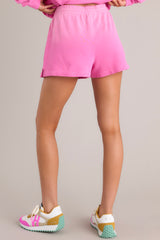 Back view of these shorts that feature a high waisted design, an elastic waistband, a self-tie drawstring, an ombre design, and a split hemline.