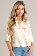 Ivory print button front top with short sleeves and a seashell beach pattern. 