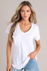 Front view of  this jersey tee that features a curved v-neckline, raw edge breast pocket, short sleeves, and scoop hem.