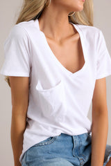 Close up view of this jersey tee that features a curved v-neckline, raw edge breast pocket, and short sleeves.