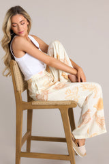 These ivory pants feature an elastic waistband, a drawstring tie, a wide leg design, and a beachy seashell print throughout.