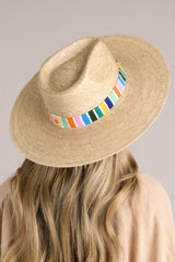 Side view of this hat that features a multicolor cotton woven band, and is handmade with palm fronds.