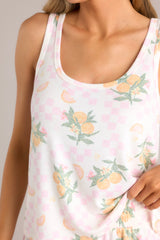 Close up view of this top that features a scoop neckline, a tank top design, a soft & lightweight material, and a citrus pattern.