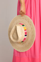 This palm hat features a cotton woven band with vibrant colors, and is handmade with palm fronds.