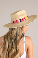 Side view of this hat that features a cotton woven band with vibrant colors, and is handmade with palm fronds.
