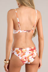 Back view of bikini top featuring a hook closure, adjustable straps, removable pads, and a floral print.