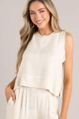 Front view of this tank that features a raw crew neckline, a keyhole with a button closure, a lightweight fabric, a split hemline, and a slightly cropped length.