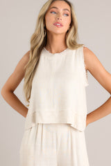 Full front view of this tank that features a raw crew neckline, a keyhole with a button closure, a lightweight fabric, a split hemline, and a slightly cropped length.
