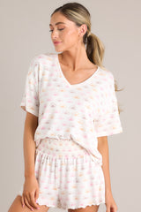 This white top features a v-neckline, a sun print, short sleeves, and a cozy lightweight fabric.