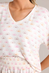Close up view of this white top featuring a v-neckline, a sun print, short sleeves, and a cozy lightweight fabric.