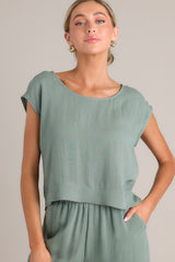 This green top features a rounded neckline, a lightweight material, and wide short sleeves.