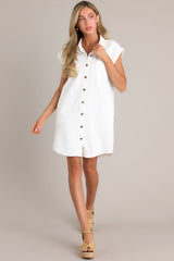 This white dress features a collared neckline, a full button front, functional breast & hip pockets, and folded short sleeves.