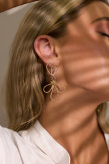 These gold earrings feature gold hardware, a twisted texture, a unique design, and secure post backings.