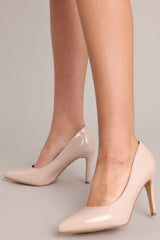 Beige heels with a pointed toe, vibrant color, glossy finish, and skinny heel.