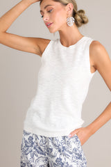Full front view of this top that features a high round neckline, a sleeveless design, a high back, ribbed texture around the hemlines, and a light breathable fabric.