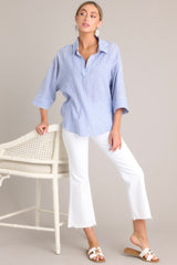This blue collared top features a v-neckline, three-quarter length sleeves, and a subtle pleat in the back.
