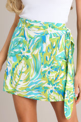 Front view of this skirt that features a high waisted design, a discrete side zipper, a self-tie wrap feature, and a vibrant print.
