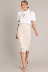 Full body angled view of this beige midi skirt features a high waisted design, an elastic waistband, and a delicate lace overlay.