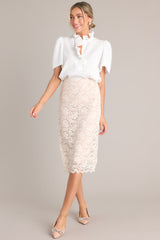 Full body view of this beige midi skirt features a high waisted design, an elastic waistband, and a delicate lace overlay
