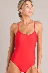 Front view of this one piece that features a rounded neckline, removable paddings, thin & adjustable self-tie straps that cross in the back, and a full-coverage backside.
