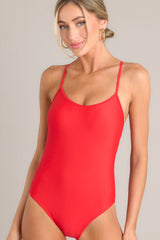 This red one piece features a rounded neckline, removable paddings, thin & adjustable self-tie straps that cross in the back, and a full-coverage backside.