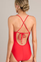 Back view of this one piece that features a rounded neckline, removable paddings, thin & adjustable self-tie straps that cross in the back, and a full-coverage backside.