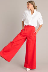These red pants feature a high waisted design, an elastic insert, a discrete side zipper, subtle pleats, functional hip pockets, faux back pockets, and a thick hemline.