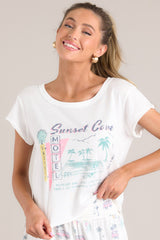 Front view of this tee that features a crew neckline, a vacation themed graphic, a light & airy material, a slightly cropped length, a split hemline, and short sleeves.