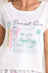 Close up view of this tee that features a crew neckline, a vacation themed graphic, a light & airy material, a slightly cropped length, a split hemline, and short sleeves.