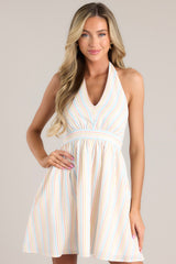 Front view of this dress that features a self-tie halter neck, functional pockets, and an open back.