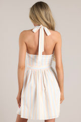 Back view of this dress that features a self-tie halter neck, functional pockets, and an open back.