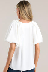 Back view of this top that features a v-neckline, pleated short sleeves, and elastic cuffs.