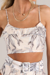 Close up view of this crop top that features a rounded neckline, thin adjustable straps, a fully smocked back, and a cropped hemline.