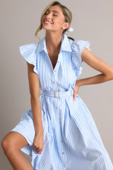 Front view of this dress that features a collared neckline, ruffle sleeves, a full button front, pleated details throughout the front, belt loops, an adjustable belt with a functional buckle, and hip pockets.