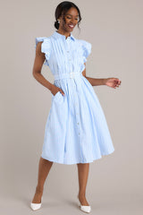 Front view of this dress that features a collared neckline, ruffle sleeves, a full button front, pleated details throughout the front, belt loops, an adjustable belt with a functional buckle, and hip pockets.