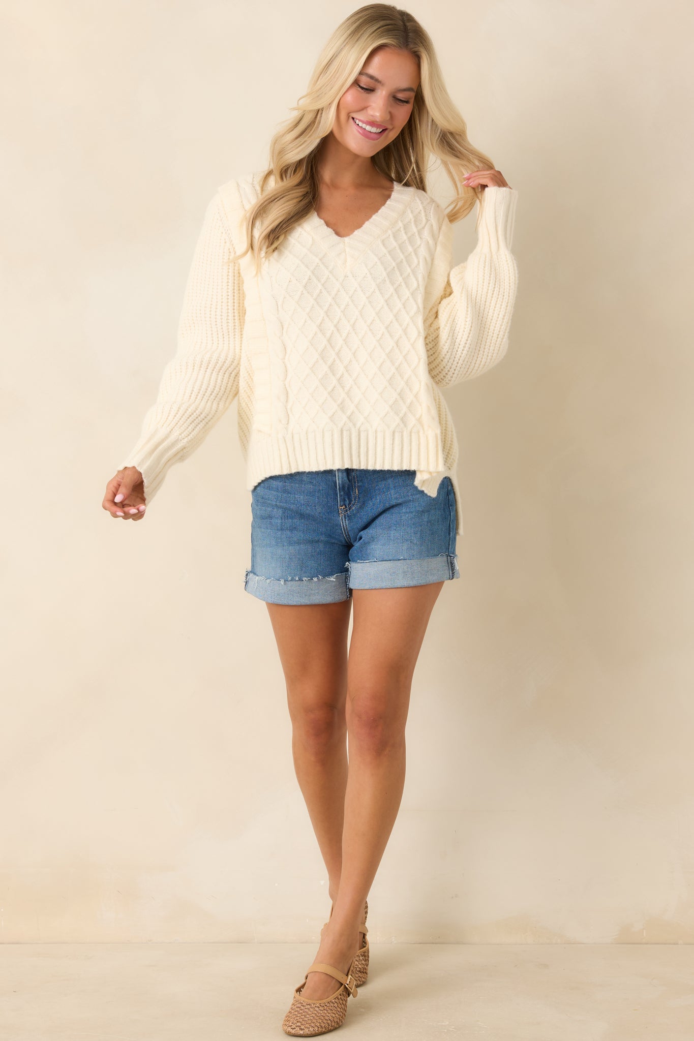 Ivory V-neck knit detail, highlighting textured stitching and clean neckline construction.