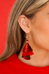 Model is shown wearing earrings that feature multicolor beads, a tree made of tinsel hanging below, and a secure fish hook backing.